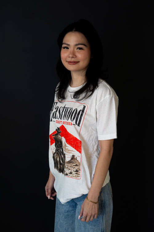 White Eastwood Craft Butcher T-shirt with cowboy on horseback and red-accented desert graphic