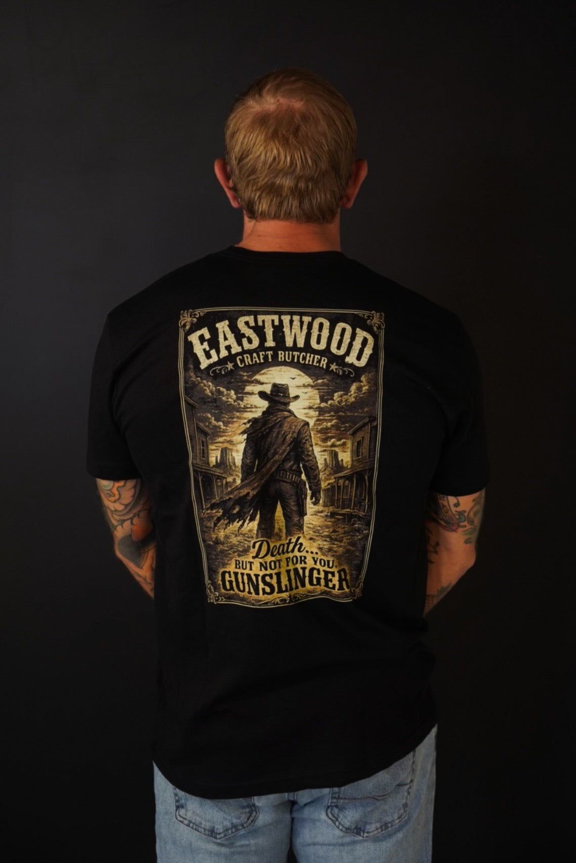 Back of black Eastwood Craft Butcher Gunslinger T-shirt with large gold-toned Western graphic